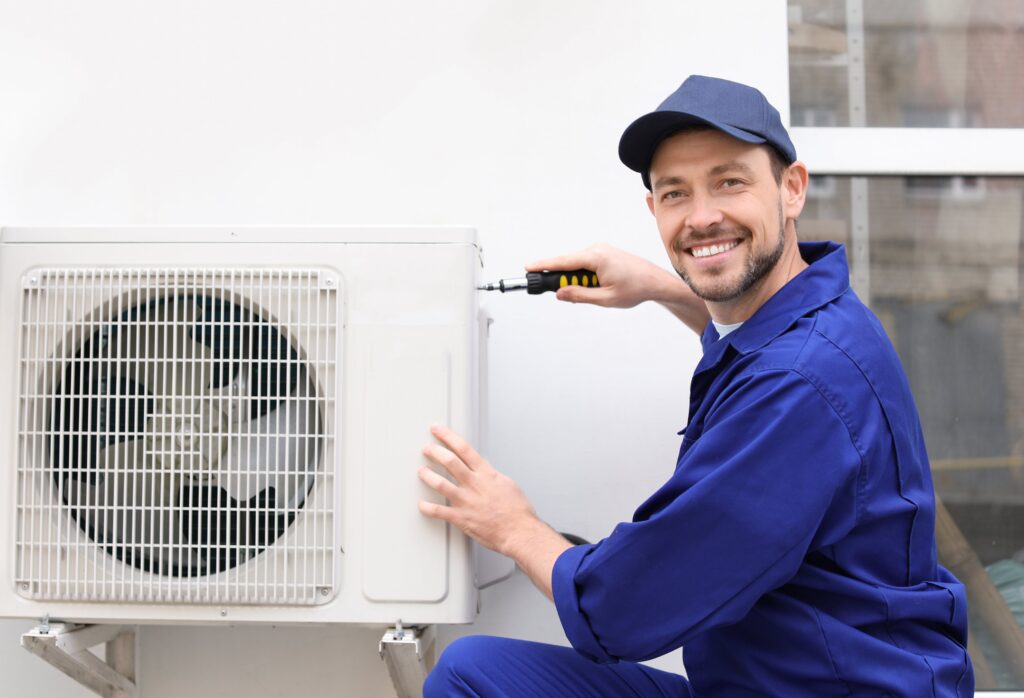 male-technician-repairing-air-conditioner-outdoors-min