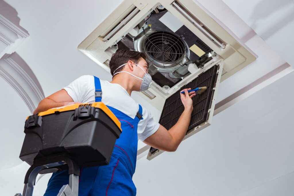 worker-repairing-ceiling-air-conditioning-unit-min